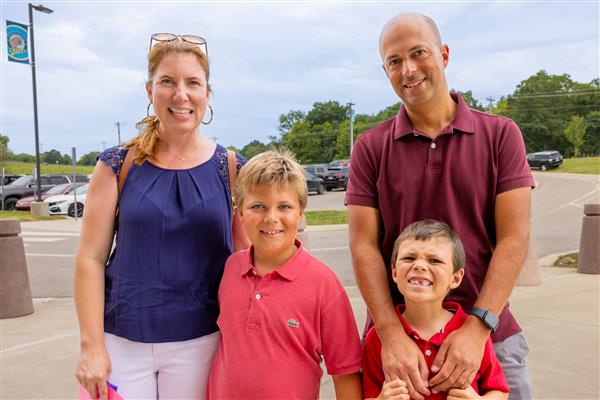 family smiling near parking lot